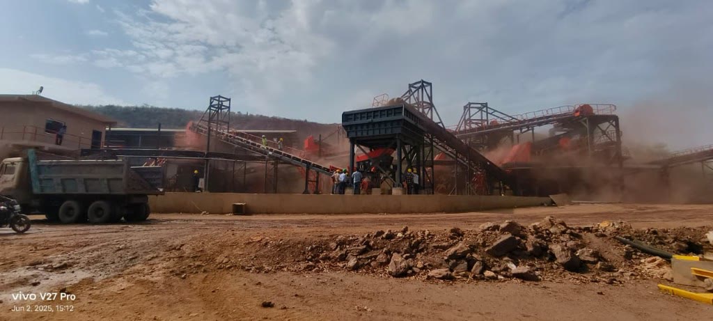Iron ore crushing and conveyor plant with workers on site