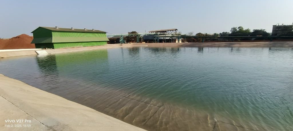 Iron ore stockpile, plant building and settling pond
